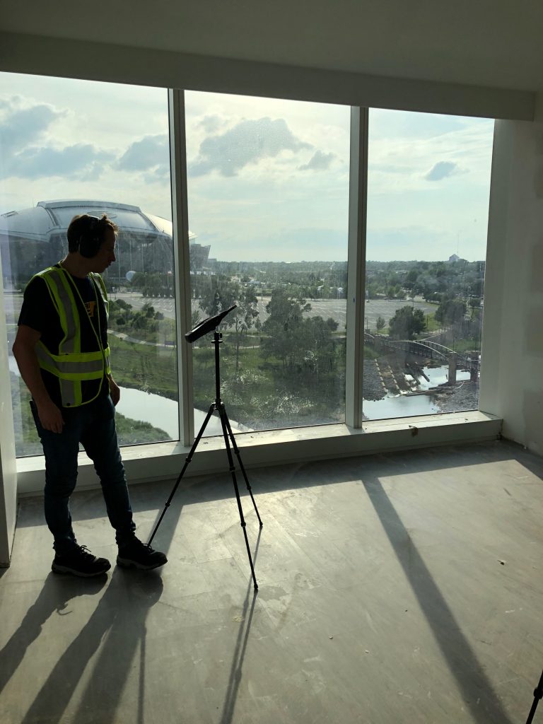 Technician performing OITC acoustic testing of an exterior window assembly